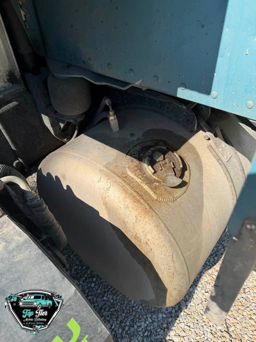 A semi truck fuel tank covered in road film and oxidation